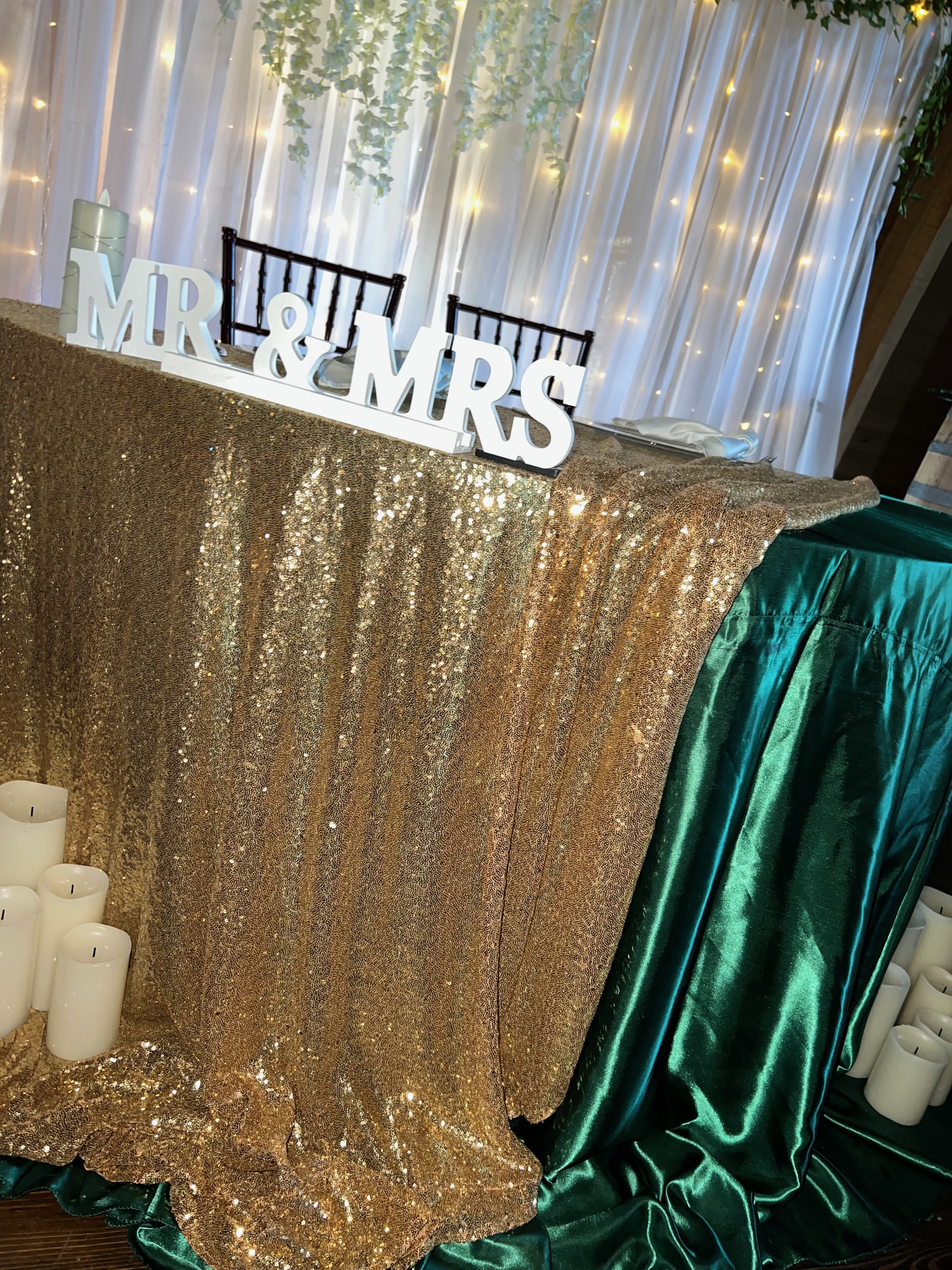 Sweetheart table with gold sequin and emerald satin linen